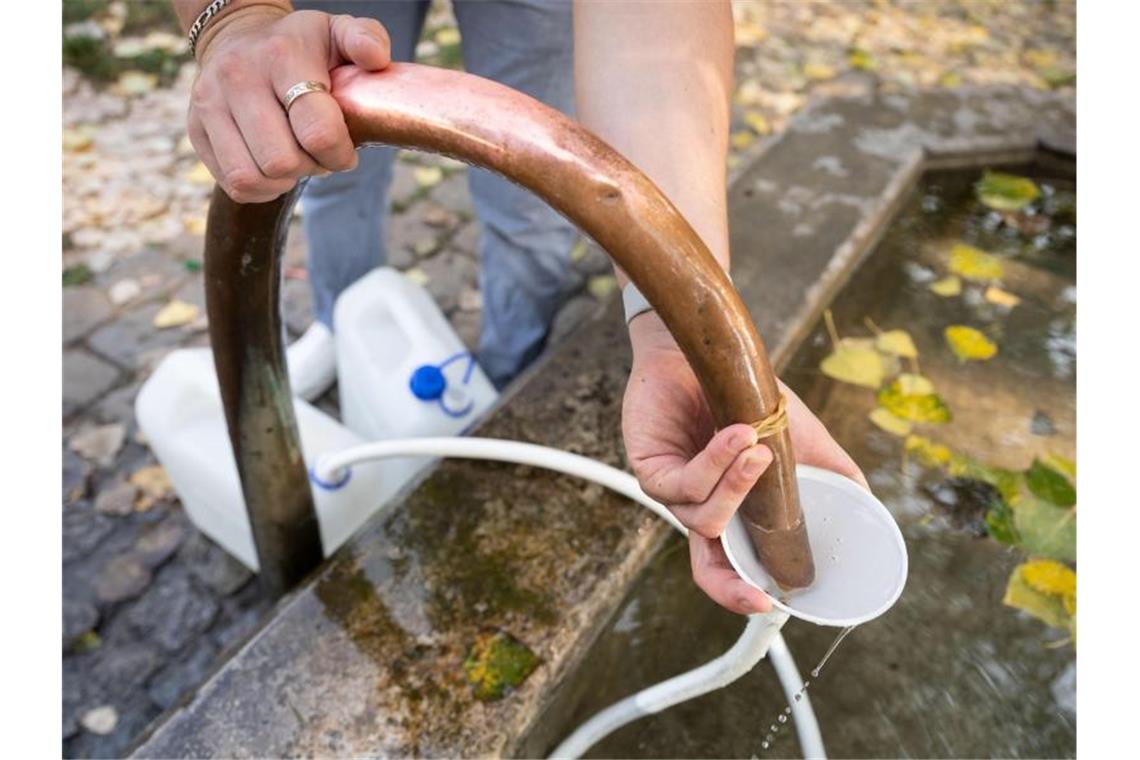 Ein Mann füllt am Auquellbrunnen Mineralwasser in Trinkwasserkanister ab. Foto: Marijan Murat/dpa