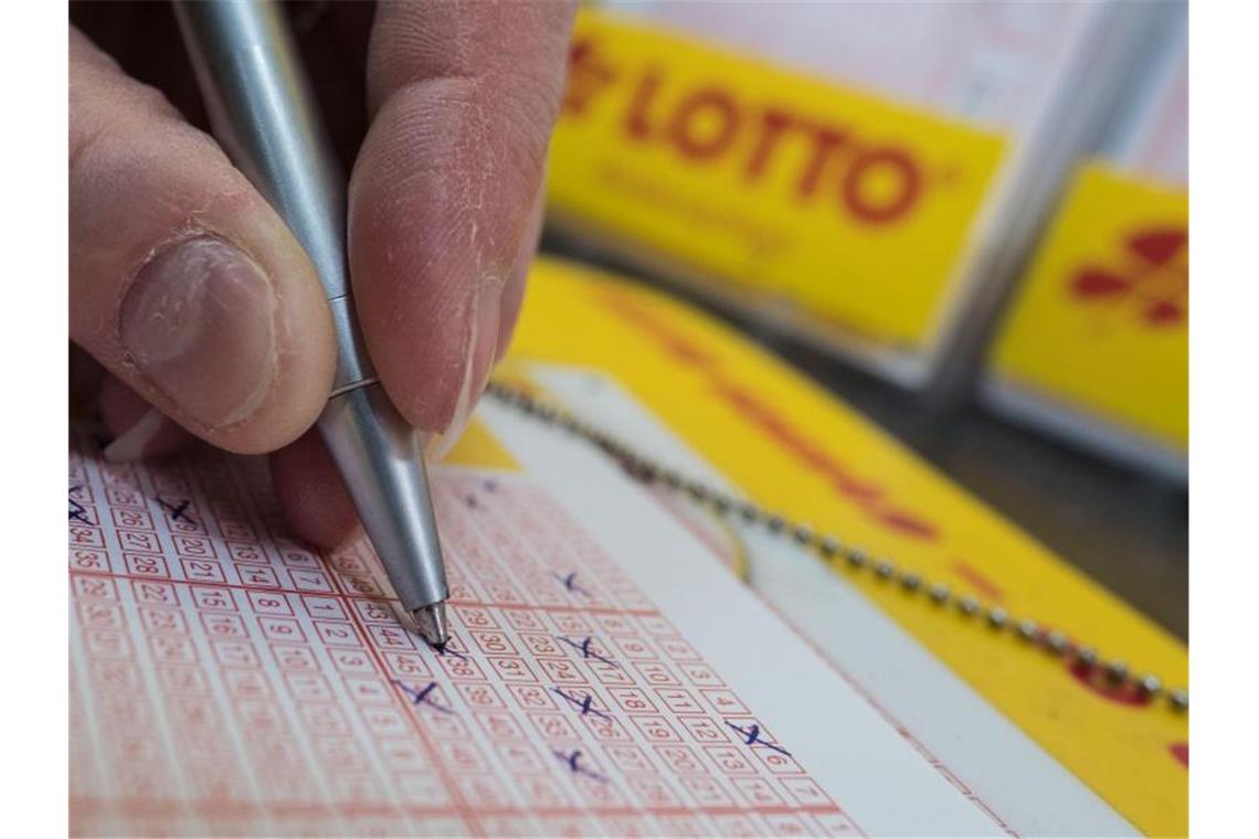 Ein Mann füllt einen Lottoschein aus. Foto: Peter Steffen/dpa