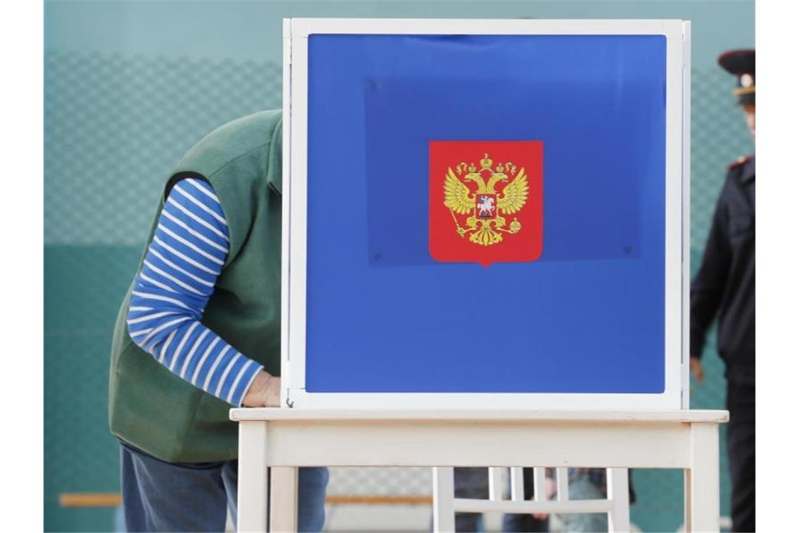 Ein Mann füllt in einer Wahlkabine in St. Petersburg seinen Stimmzettelaus. Foto: Dmitri Lovetsky/AP
