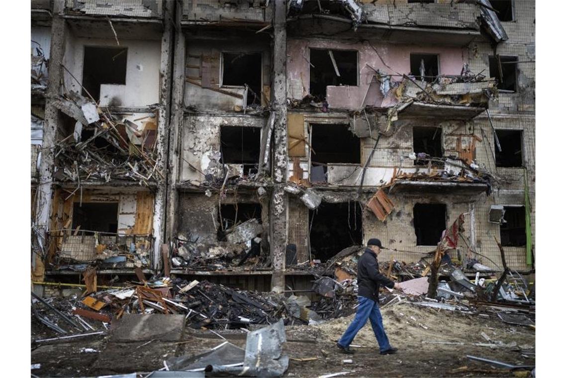 Ein Mann geht an einem Gebäude in der ukrainischen Hauptstadt Kiew vorbei, das nach einem Raketenangriff beschädigt wurde. Foto: Emilio Morenatti/AP/dpa