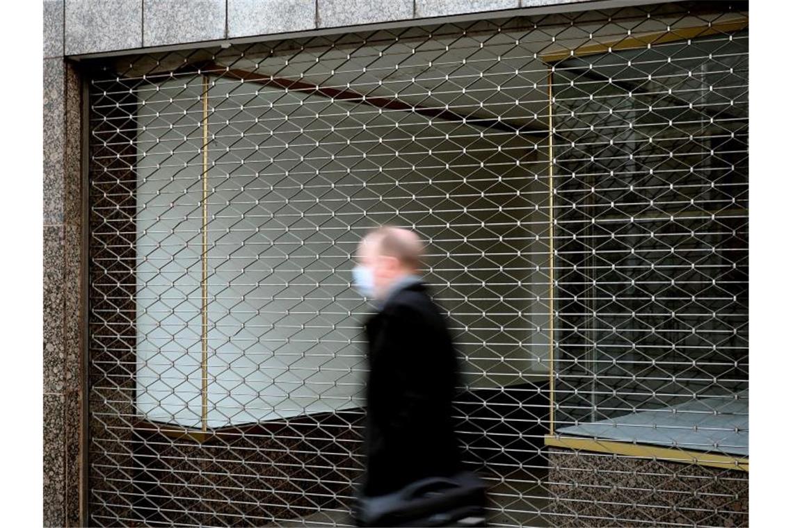 Ein Mann geht an einem leerstehenden Ladenlokal in Köln vorbei. Foto: Oliver Berg/dpa