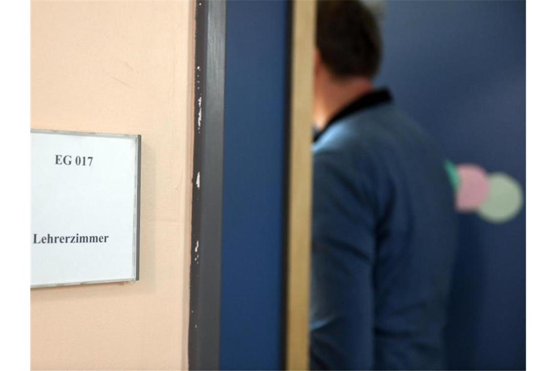 Ein Mann geht an einem Schild vorbei, das den Weg zum Lehrerzimmer weist. Mehr Schulleitungen berichten von Übergriffen von auf das Lehrerpersonal. Foto: Maurizio Gambarini/dpa