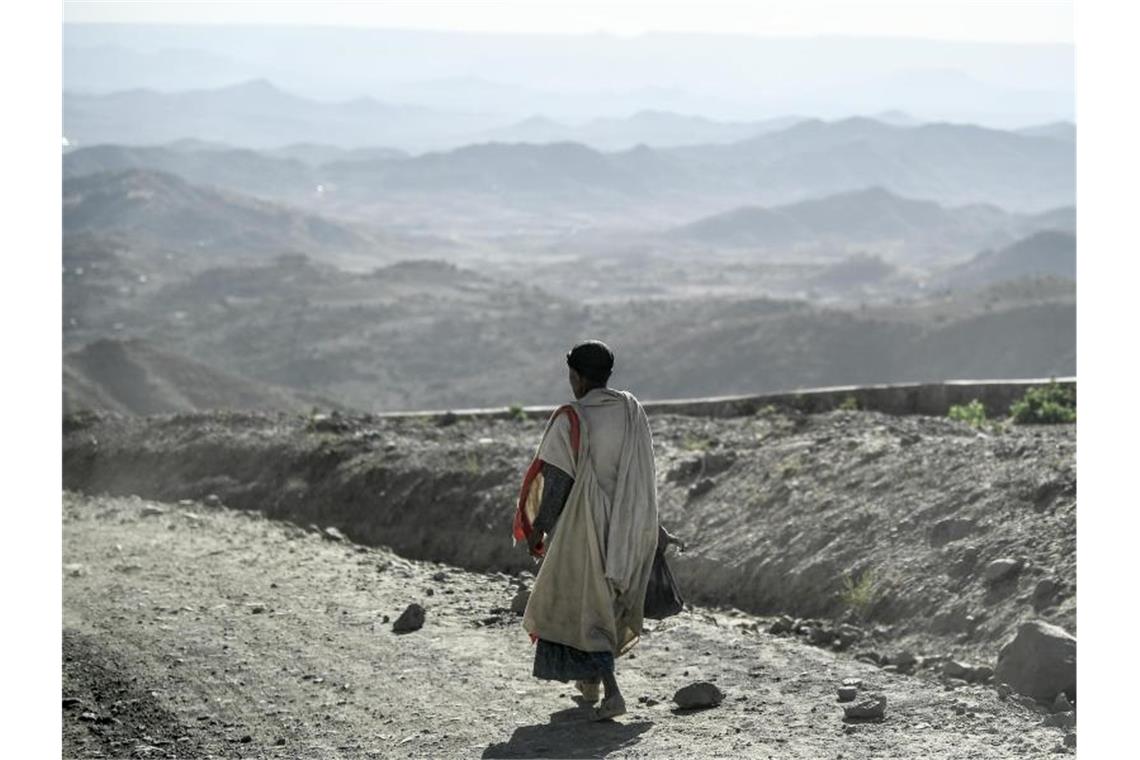Ein Mann geht entlang einer staubigen Landstraße in Äthiopien. 3,5 Milliarden Menschen würden in etwa 50 Jahren in Gebieten leben, in der die jährliche Durchschnittstemperatur mehr als 29 Grad Celsius beträgt - sollte der Ausstoß der Treibhausgase nicht gemindert werden. Foto: Britta Pedersen/dpa-Zentralbild/dpa