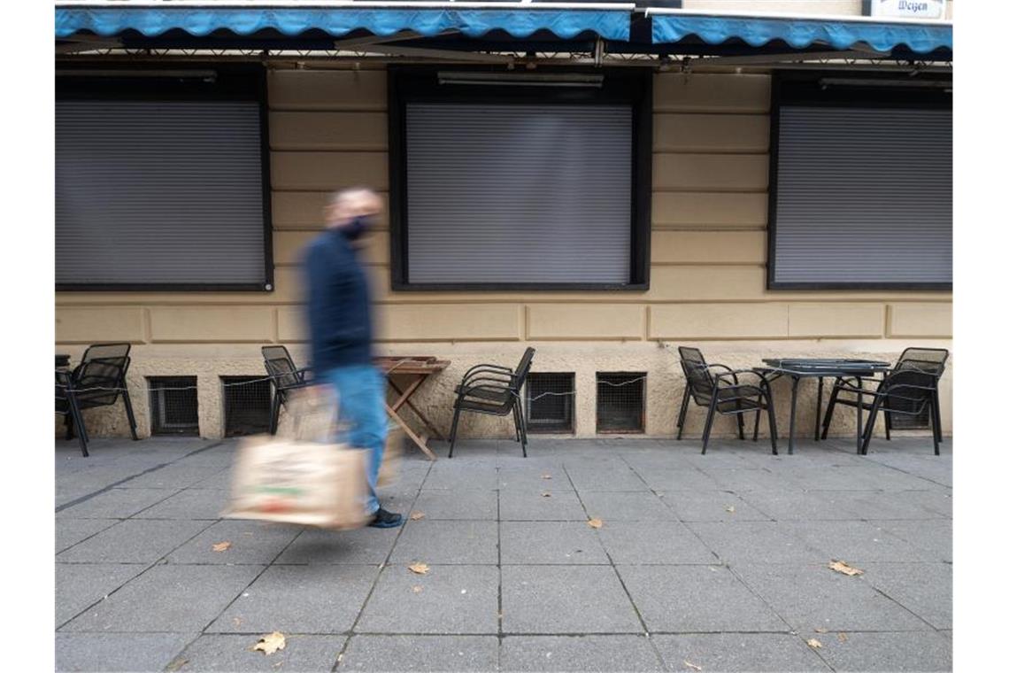 Anträge gegen Corona-Verordnung ab Freitag vor Gericht Ein Mann geht in Stuttgart an einem geschlossenen Restaurant vorbei. Foto: Sebastian Gollnow/dpa