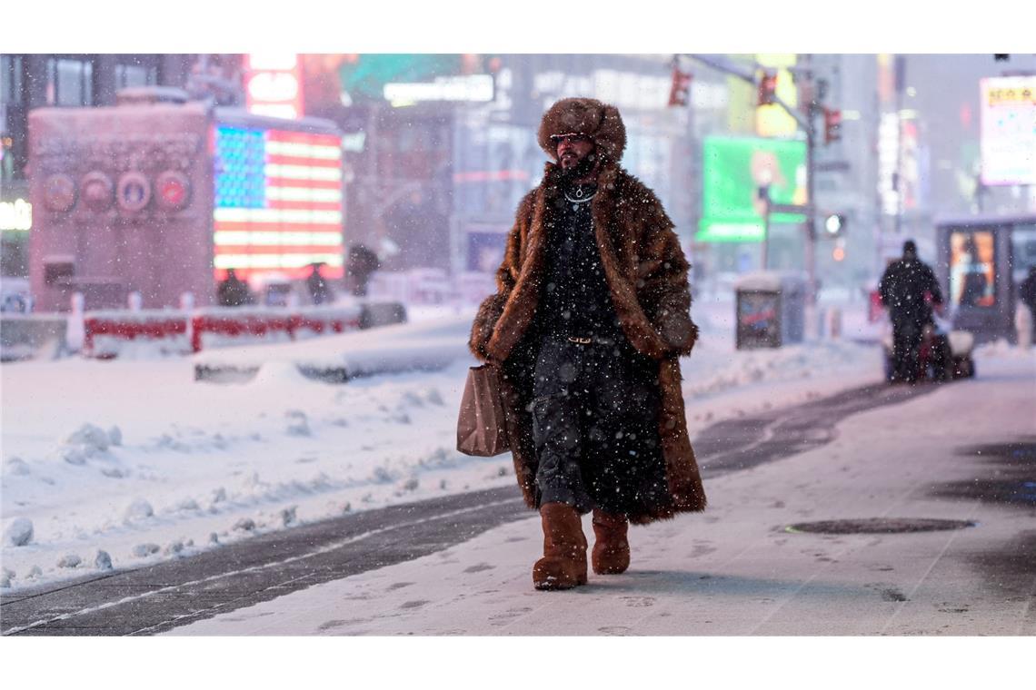 Ein Mann geht während eines Schneesturms über den Times Square in New York.