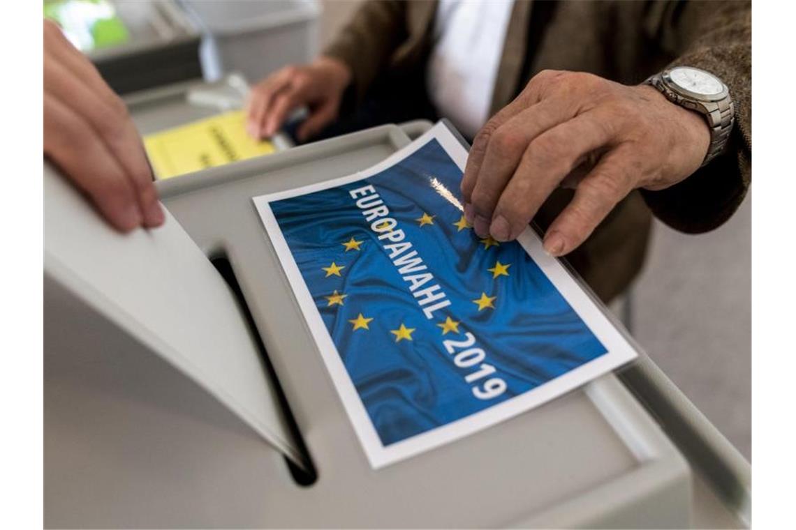 Ein Mann gibt im Wahllokal seinen Stimmzettel zur Europawahl ab. Foto: Patrick Seeger