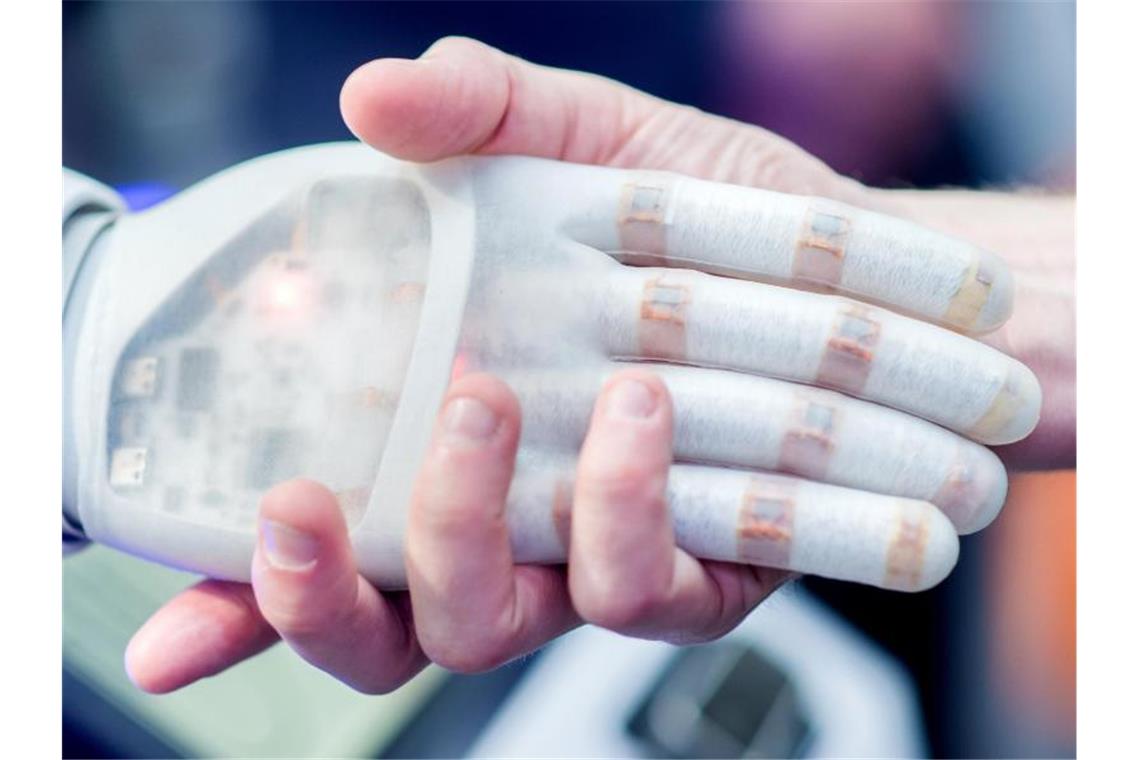 Eine halbe Million Euro für Künstliche Intelligenz Ein Mann hält am Stand des Unternehmens Festo auf der Hannover Messe die Hand eines bionischen Roboters. Foto: Hauke-Christian Dittrich/dpa