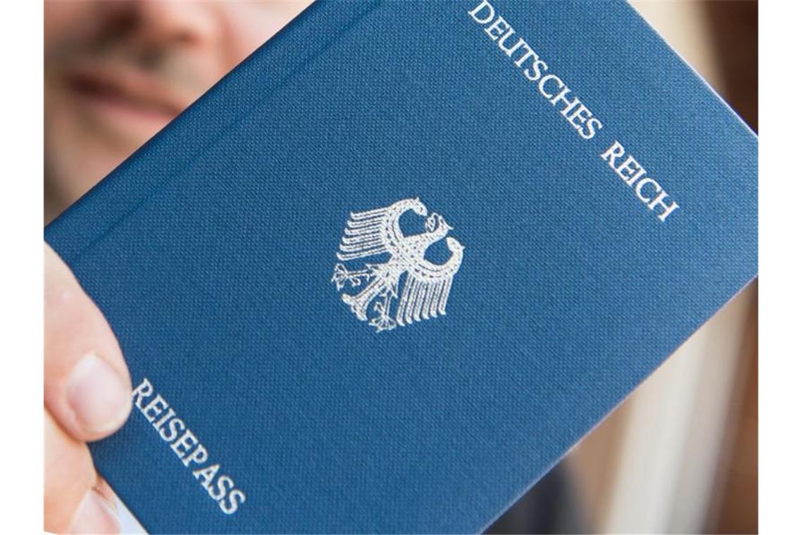Ein Mann hält ein Heft mit dem Aufdruck „Deutsches Reich Reisepass“ in der Hand. Foto: Patrick Seeger/Archivbild