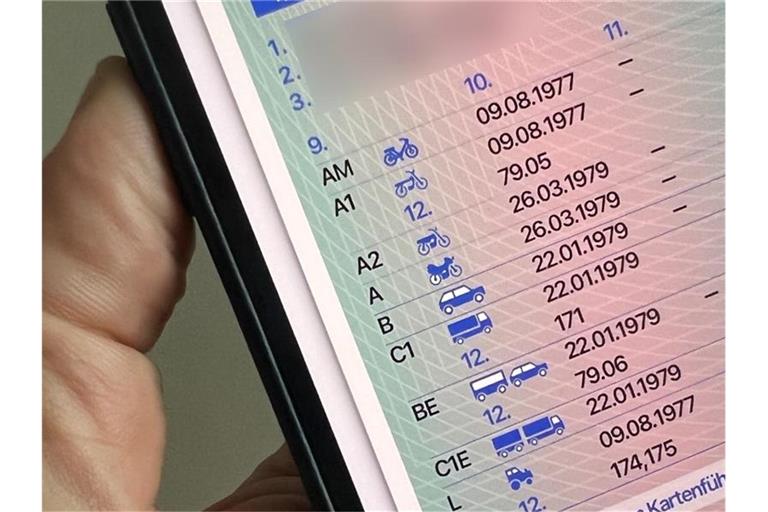 Ein Mann hält ein iPhone mit der App "ID Wallet", in der die digitale Variante eines Führerscheins zu sehen ist. Foto: Christoph Dernbach/dpa