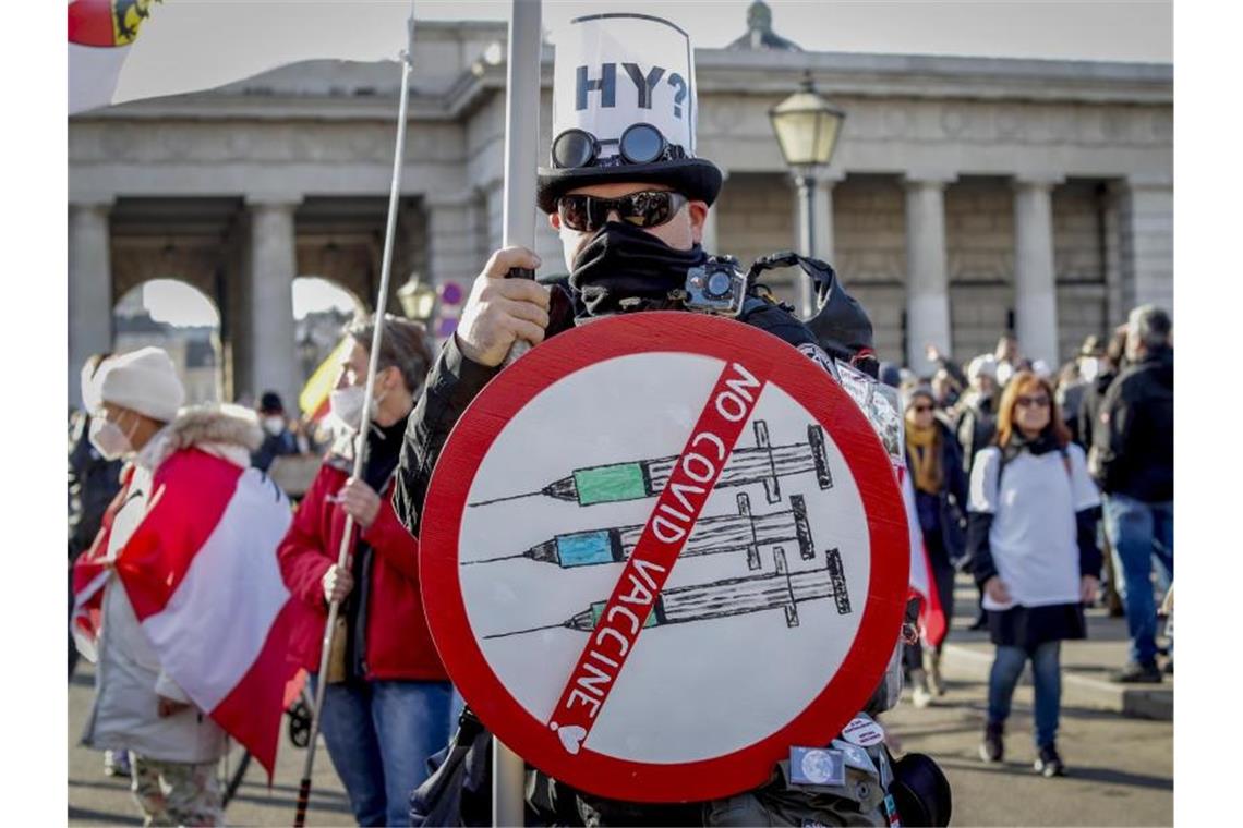 Zehntausende protestieren in Österreich gegen Lockdown Ein Mann hält ein Schild gegen die Coronaimpfung hoch. Foto: Lisa Leutner/AP/dpa
