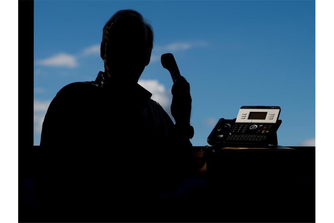 Ein Mann hält ein Telefon. Foto: Julian Stratenschulte/dpa/Symbolbild