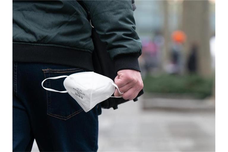 Ein Mann hält eine FFP2-Maske in der Hand. Foto: Sebastian Kahnert/dpa-Zentralbild/dpa/Symbolbild
