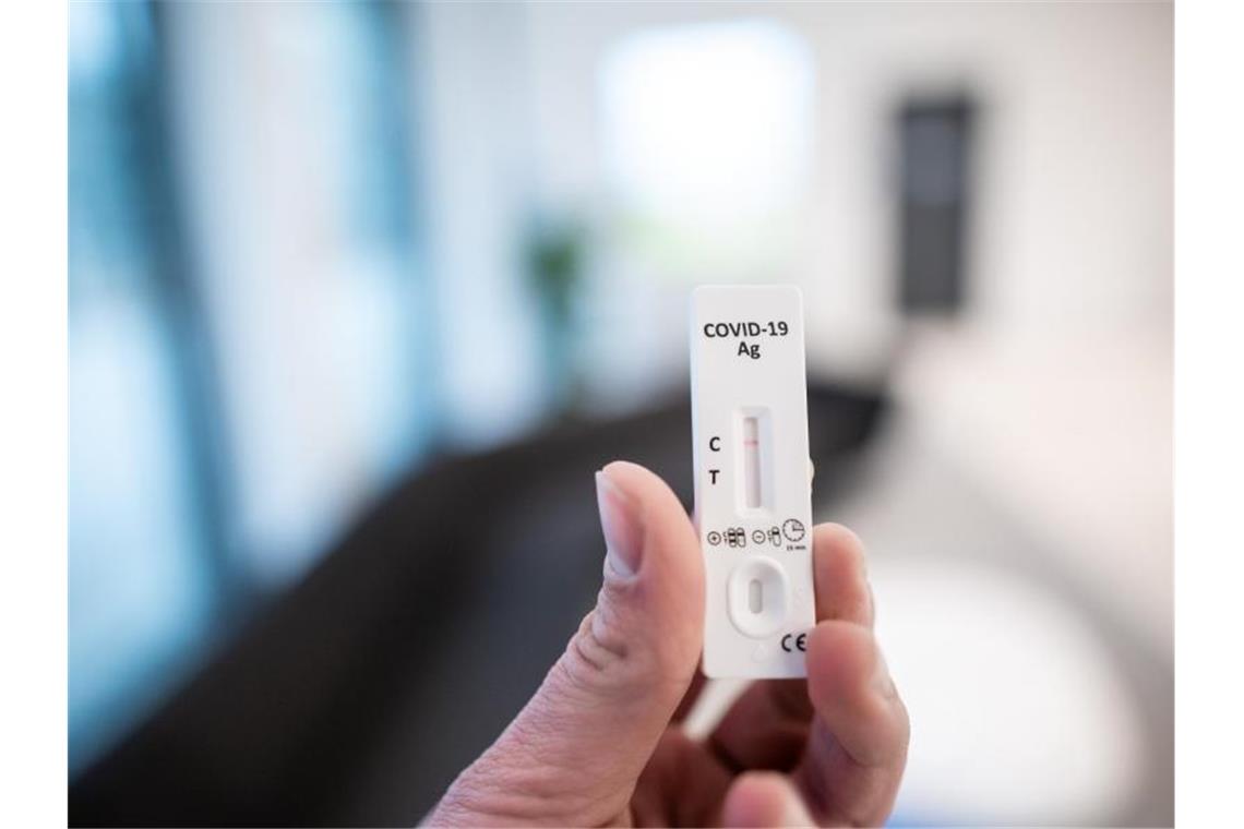 Tägliches Testen für ungeimpfte Lehrer und Kita-Beschäftigte Ein Mann hält einen Corona-Schnelltest in der Hand. Foto: Fabian Strauch/dpa/Symbolbild