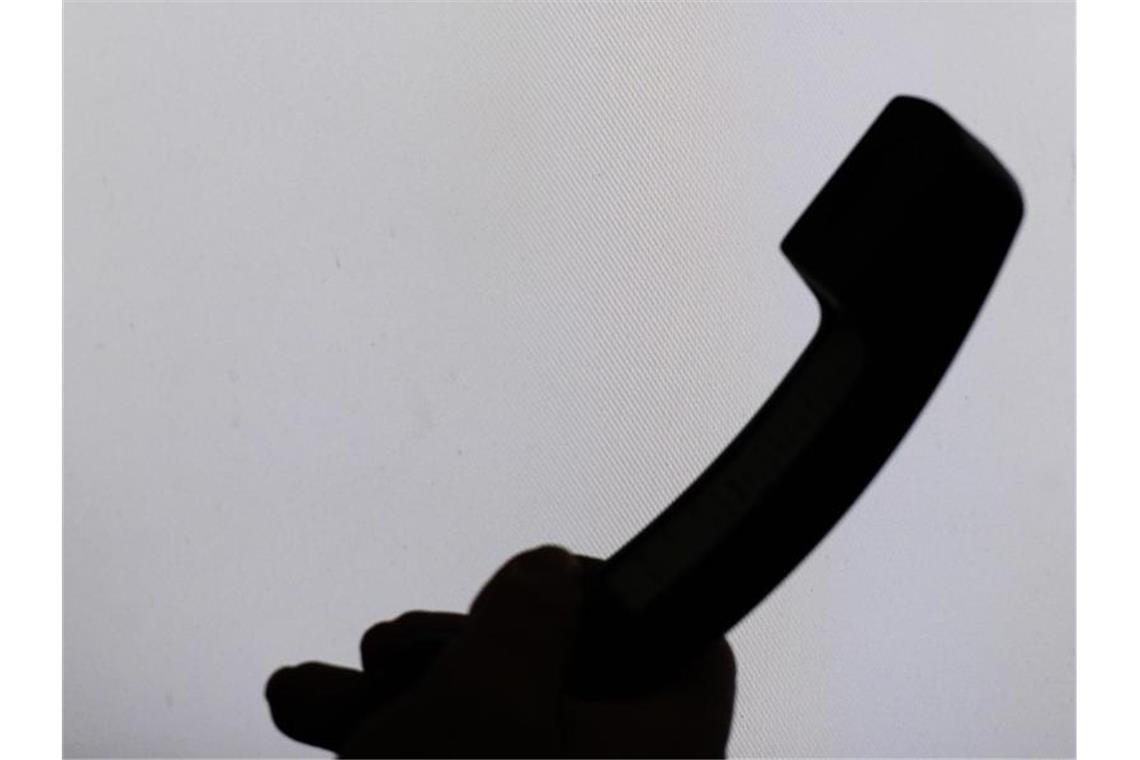 Land und Häftling einigen sich im Streit um Telefongebühren Ein Mann hält einen Telefonhörer. Foto: Armin Weigel/dpa/Symbolbild