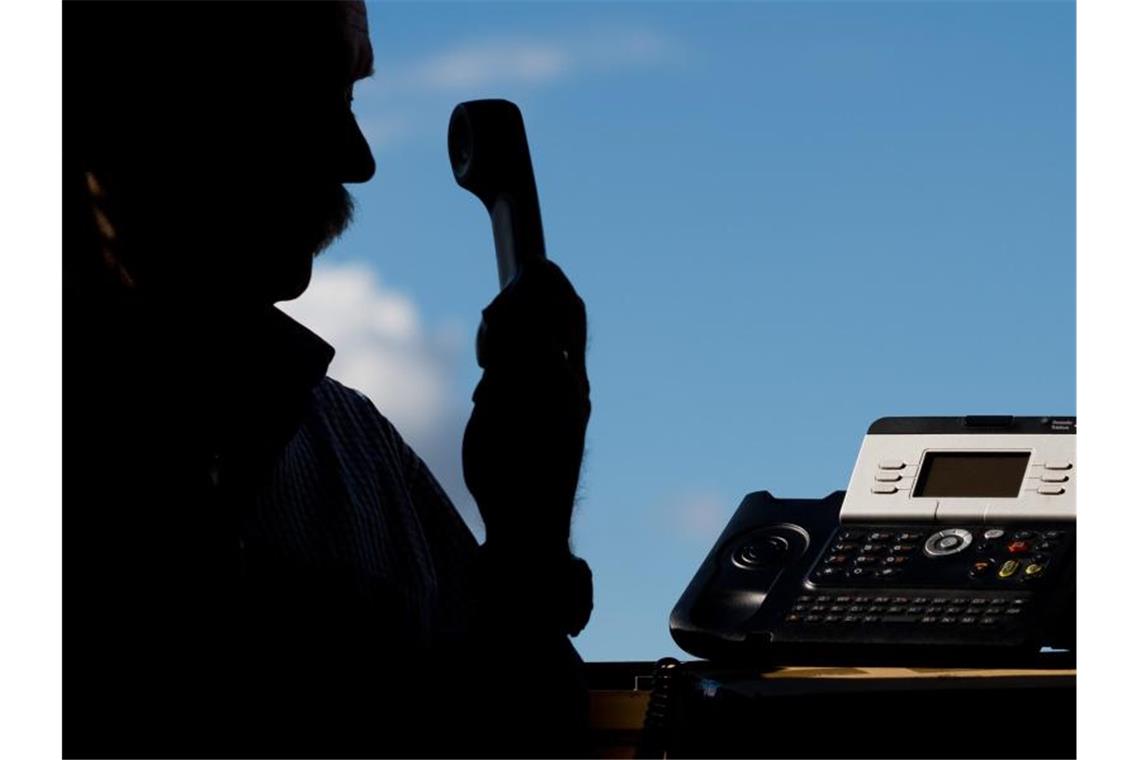 Ein Mann hält einen Telefonhörer in der Hand. Foto: Julian Stratenschulte/dpa/Symbolbild