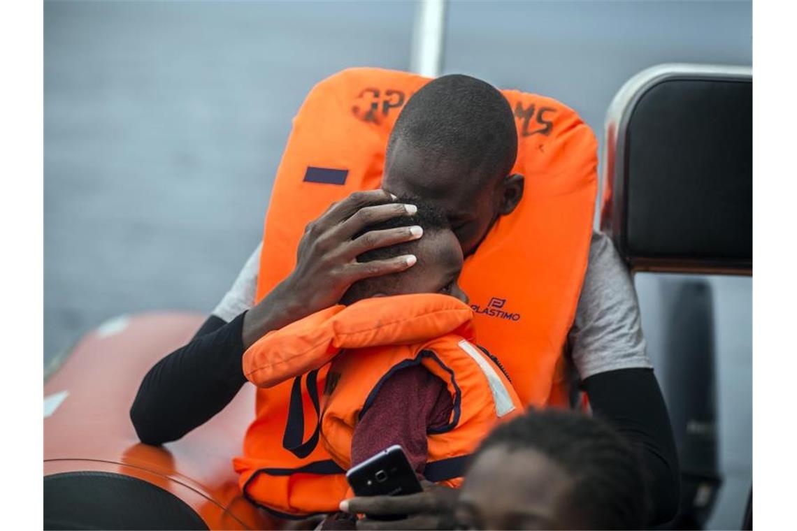 Ein Mann hält seinen Sohn im Arm, nachdem er gemeinsam mit anderen Flüchtlingen gerettet wurde. Foto: Javier Fergo/AP/dpa