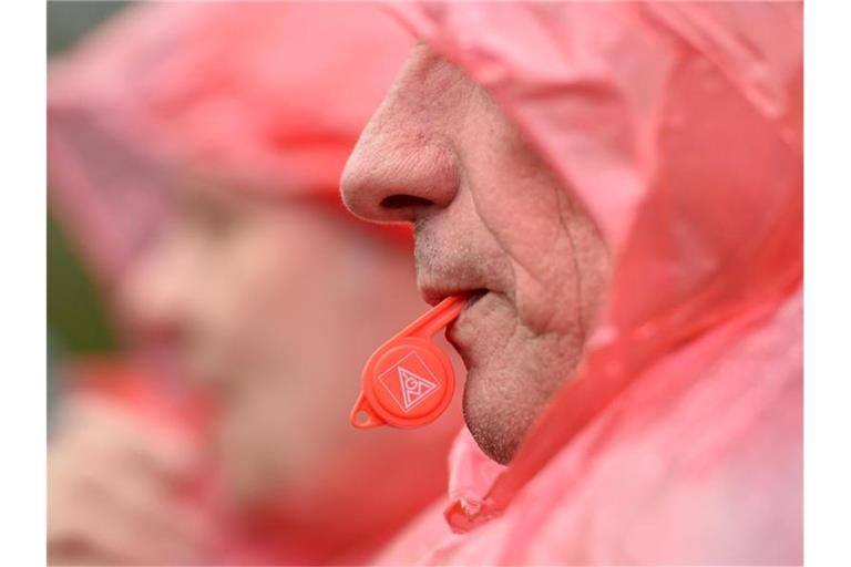 Ein Mann hat bei einer Kundgebung eine Trillerpfeife mit dem IG Metall Logo im Mund. Foto: Caroline Seidel/dpa/Archivbild