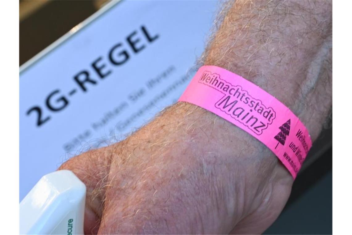 Handel wirbt für bundesweite „Bändchenlösung“ beim Einkauf Ein Mann hat ein „2G-Bändchen“ am Handgelenk. In Mainz wird die Regelung bereits auf diese Weise kontrolliert. Foto: Arne Dedert/dpa