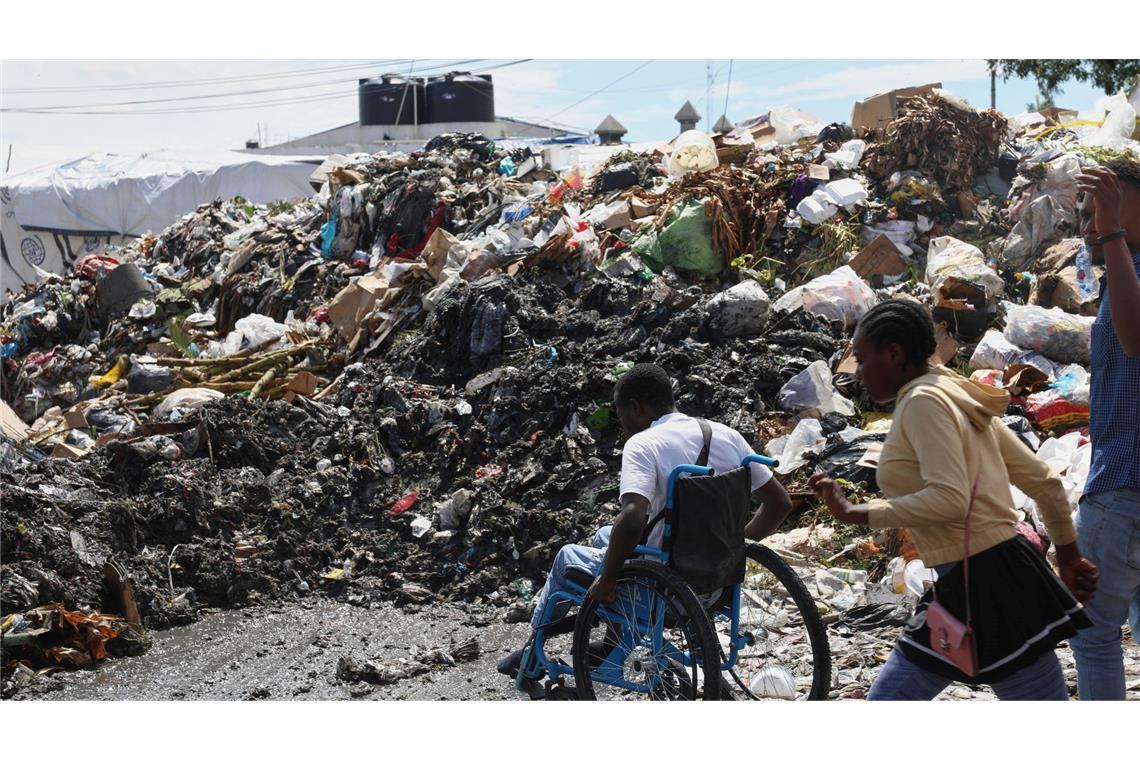 Bilder des Tages Ein Mann im Rollstuhl versucht, die Straße zu überqueren, vorbei an Müll im Viertel Petion-ville in Port-au-Prince, Haiti.