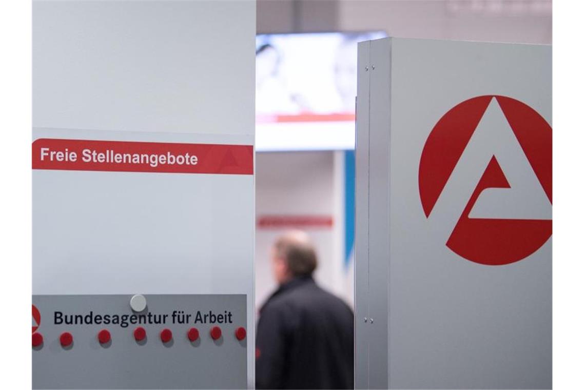 Ein Mann im Wartebereich hinter einer Stellwand für Stellenangebote in Stuttgart. Foto: Sebastian Gollnow/dpa