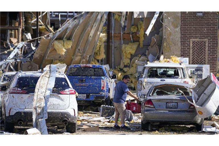 Ein Mann in Texas betrachtet ein beschädigtes Auto nachdem ein Tornado gewütet hat.