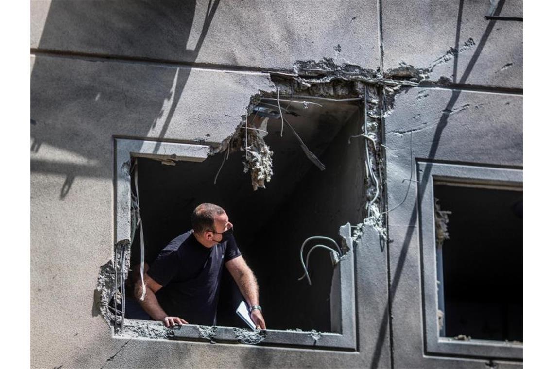 Schwere Raketenangriffe auf Tel Aviv Ein Mann inspiziert die Schäden an einem Haus in Ashkelon, das von einer aus dem Gazastreifen abgefeuerten Rakete getroffen wurde. Foto: Ilia Yefimovich/dpa