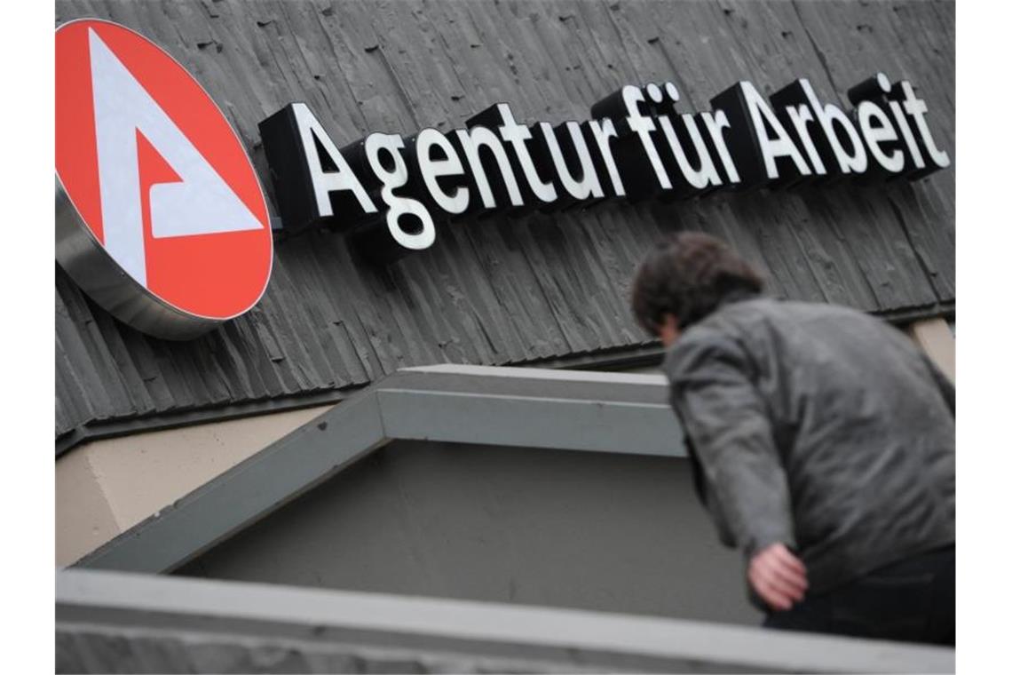 Ein Mann ist auf dem Weg zur Agentur für Arbeit. Foto: Arne Dedert/Archivbild