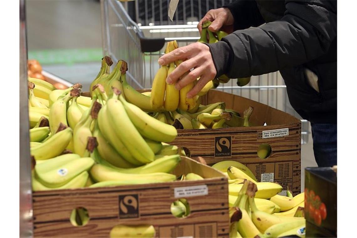 Ein Mann kauft in einem Berliner Lidl-Supermarkt Bananen ein. Foto: Wolfgang Kumm/Archivbild