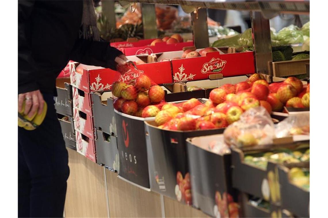 Ein Mann kauft in einem Berliner Supermarkt Obst ein. Foto: Wolfgang Kumm/dpa