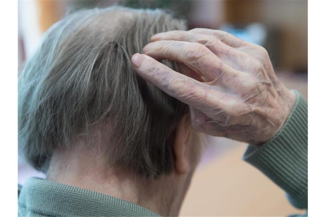 Ein Mann kratzt sich in einem Pflegeheim am Kopf. Foto: Sebastian Kahnert/Archivbild