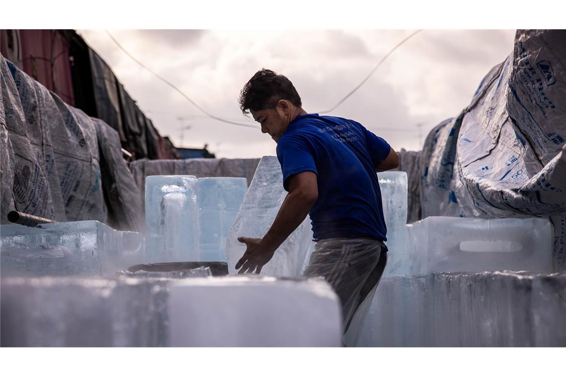 Ein Mann liefert in Bangkok Eisblöcke auf einem Markt aus. Die Menschen in Thailand sowie in weiteren Ländern in der Region stöhnen unter einer anhaltenden Hitzewelle.
