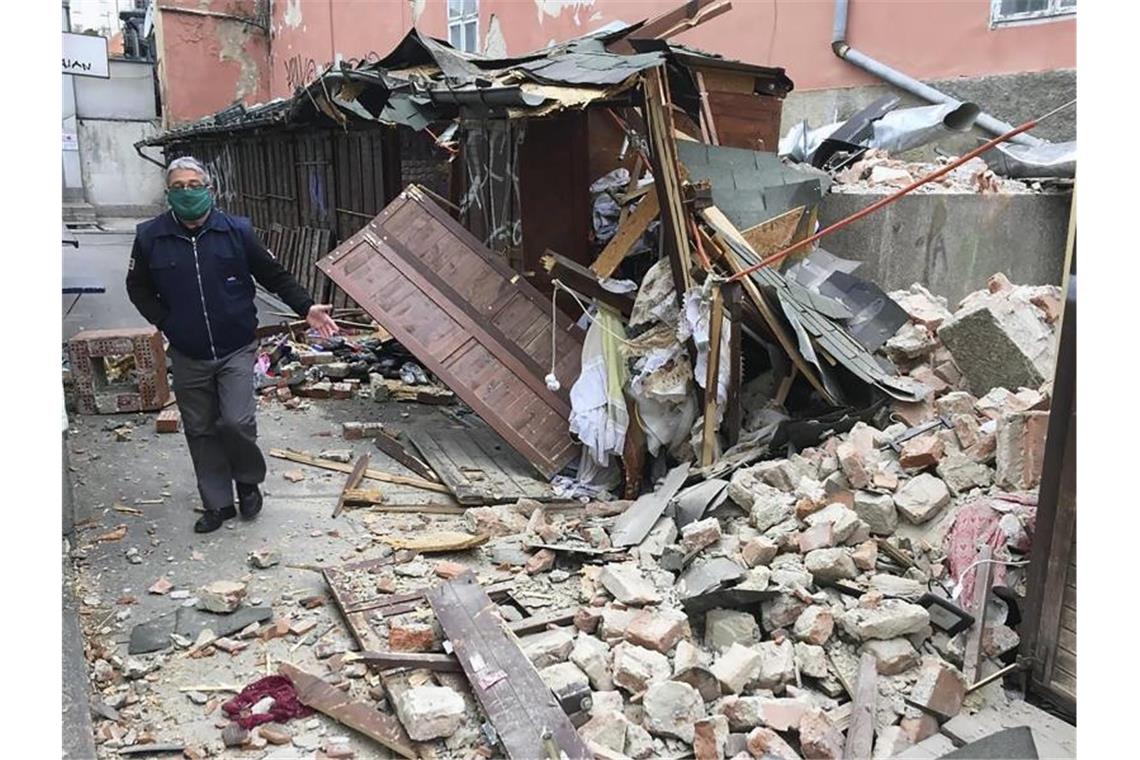 Ein Mann mit Mundschutz inspiziert die Bebenschäden in Zagreb. Foto: Filip Horvat/AP/dpa