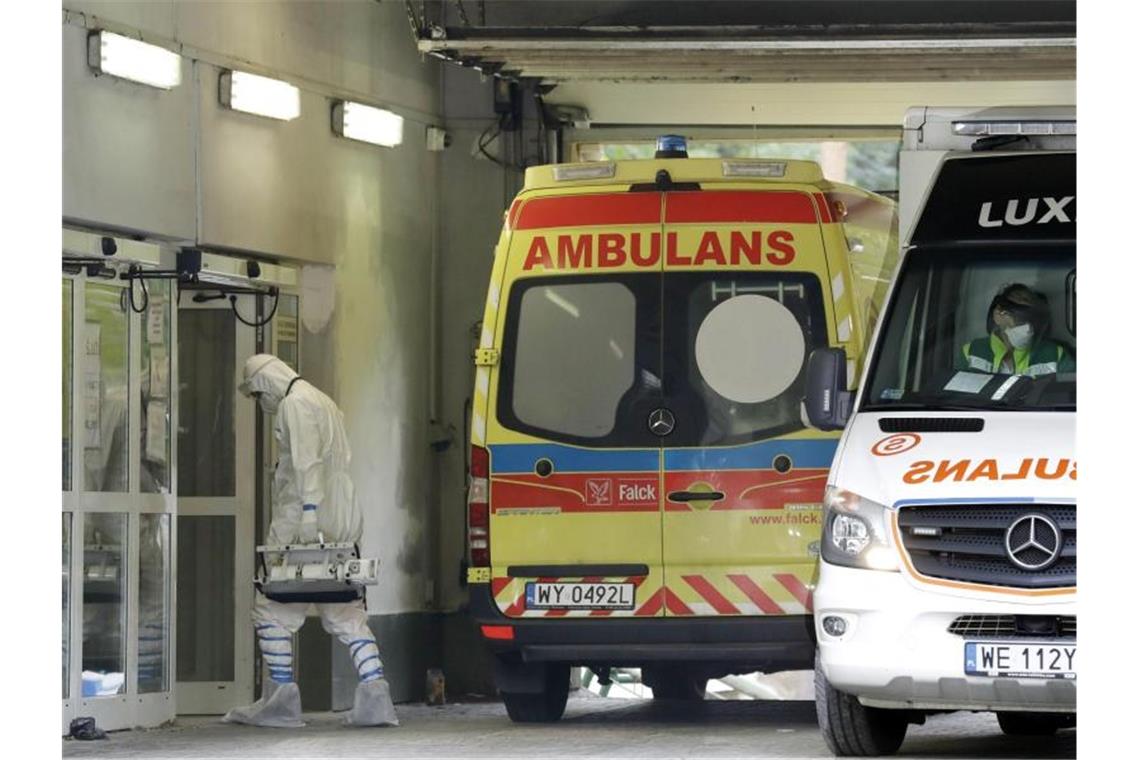 Deutschlands Nachbarländer im Kampf gegen das Coronavirus Ein Mann mit Schutzkleidung geht in Warschau in ein auf Corona-Fälle spezialisiertes Krankenhaus. Foto: Czarek Sokolowski/AP/dpa