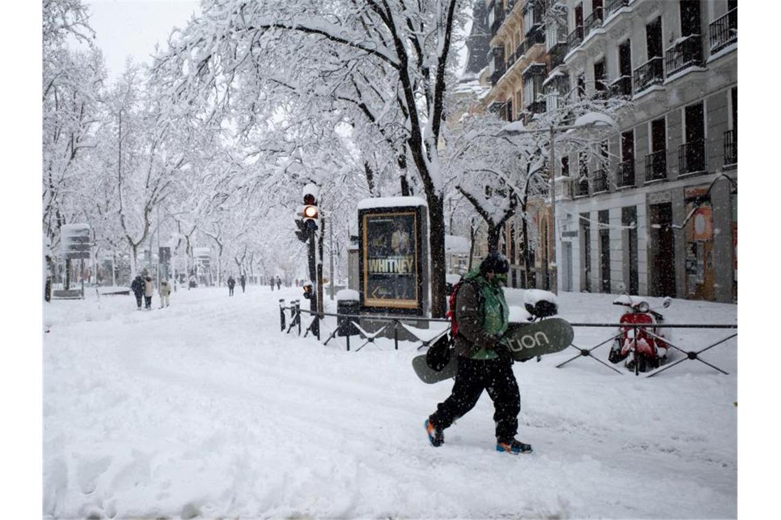 Ein Mann mit Snowboard in Madrid. Foto: Meng Dingbo