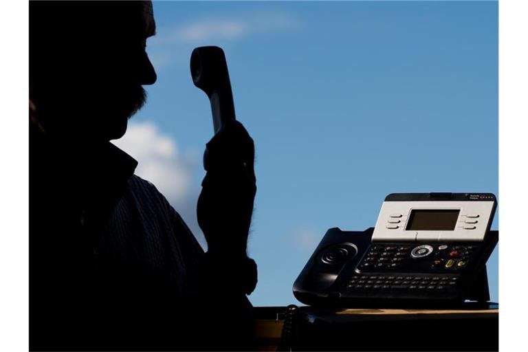 Ein Mann posiert mit einem Telefon. Foto: Julian Stratenschulte/dpa/Archivbild