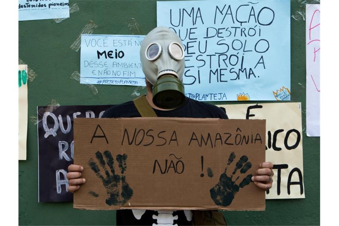 Ein Mann protestiert mit einer Gasmaske und einem Schild mit der Aufschrift „Unser Amazonas nicht!“ in der Stadt Porto Velho. Foto: Dario Oliveira/ZUMA Wire