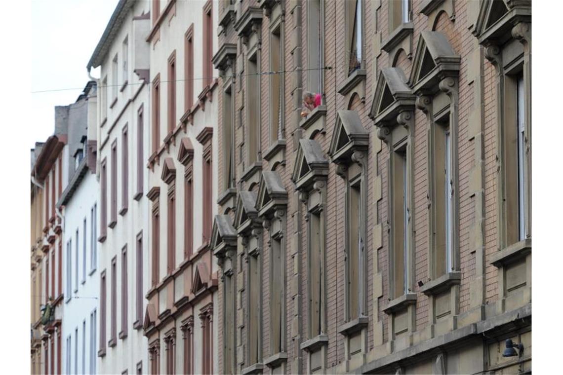 Kabinett entscheidet kommende Woche über Mietpreisbremse Ein Mann raucht am Fenster seiner Wohnung. Foto: Arne Dedert/dpa/Archivbild
