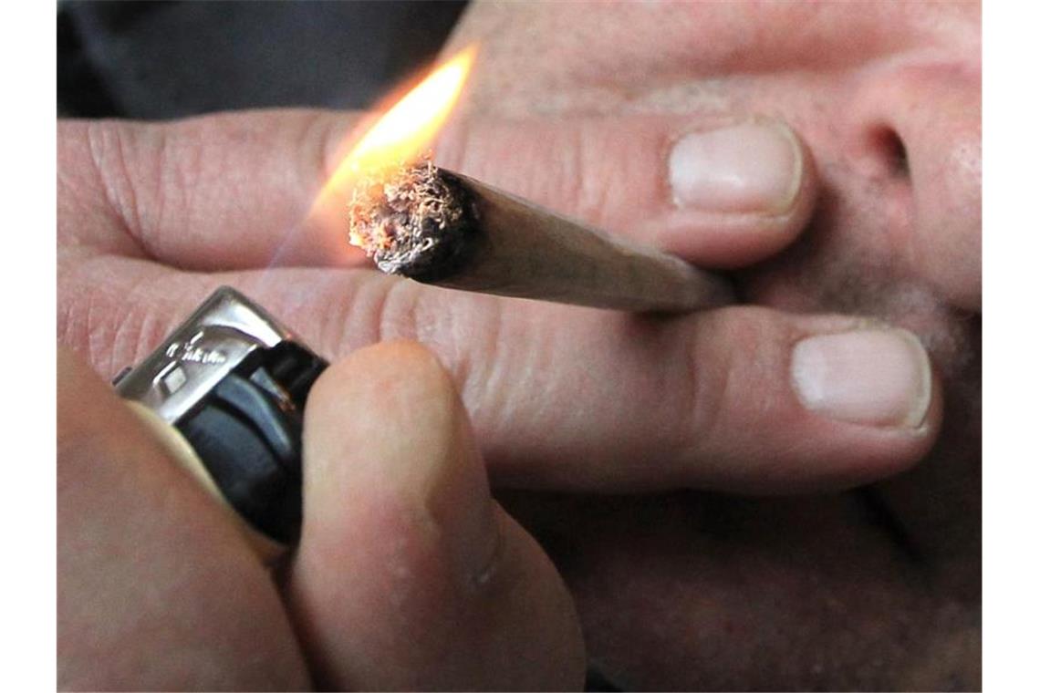 Ein Mann raucht eine selbst gedrehte Cannabis-Zigarette. Foto: picture alliance / Karl-Josef Hildenbrand/dpa/Symbolbild