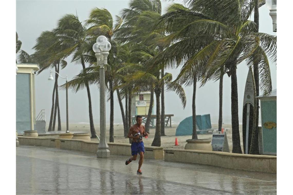 Ein Mann rennt am Hollywood Beach durch den Regen. Foto: David Santiago/Miami Herald/AP