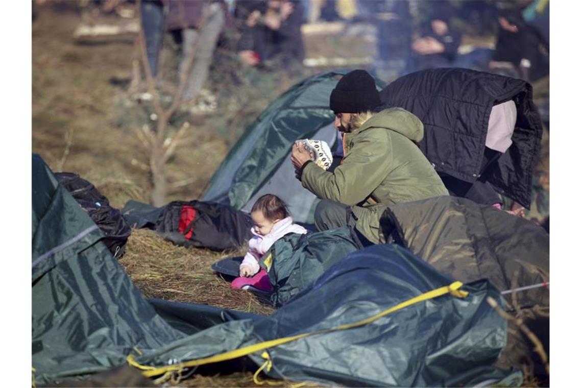 Spannungen an Polens Grenze verschärfen sich Ein Mann ruht sich mit einem Kind aus. Foto: Leonid Shcheglov/BelTA/AP/dpa