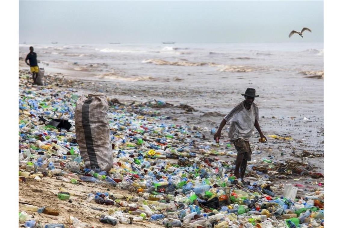 Ein Mann sammelt verwertbares Material am verschmutzten Korle Gono Strand in Ghana. Foto: Christian Thompson/EPA/dpa