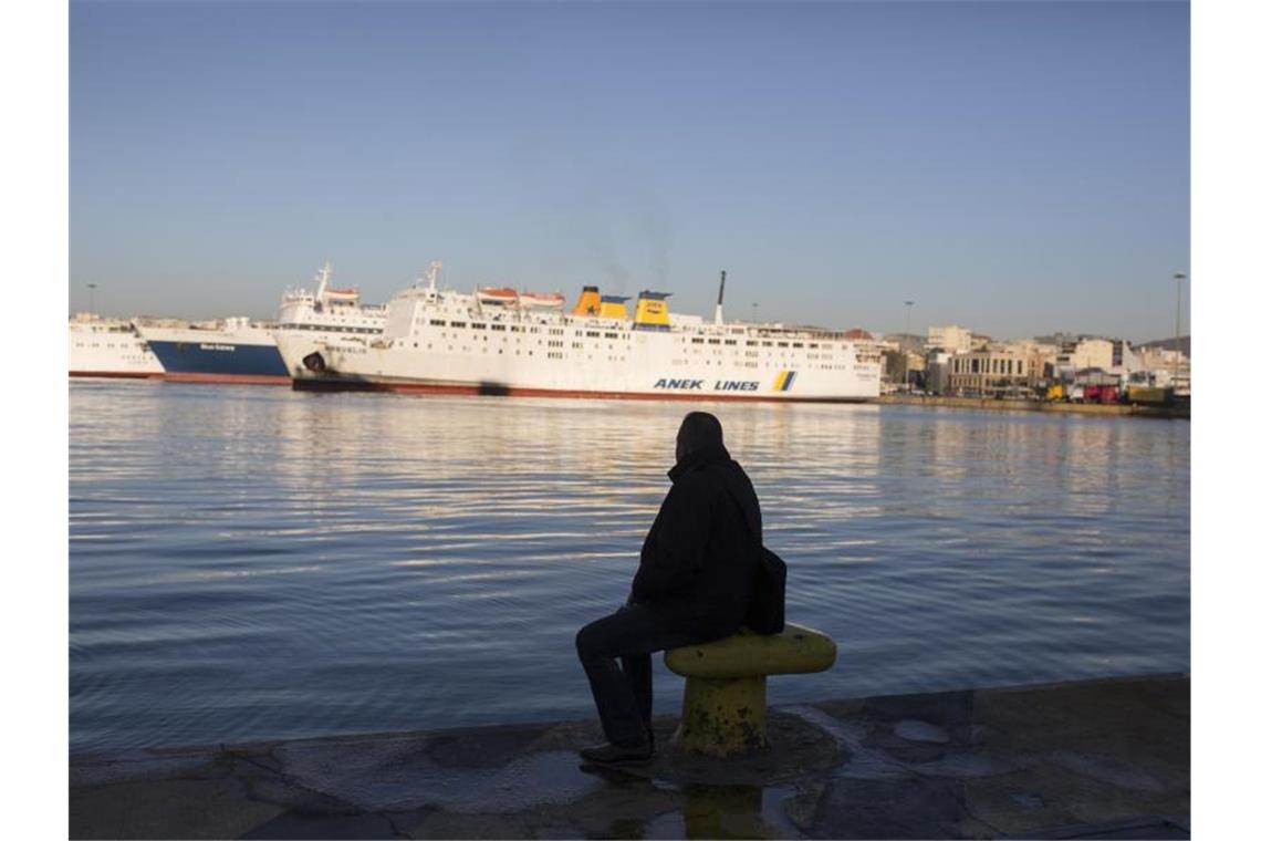 Streiks in Griechenland: Fähren liegen in den Häfen Ein Mann sitzt am Kai im Hafen von Piräus. Foto: Socrates Baltagiannis/dpa