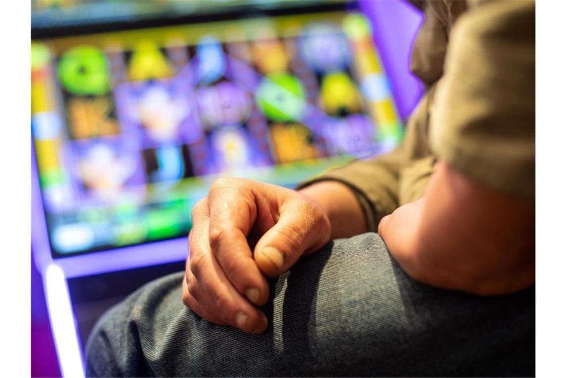 Ein Mann sitzt an einem Spielautomat. Foto: Sebastian Gollnow/dpa/Illustration