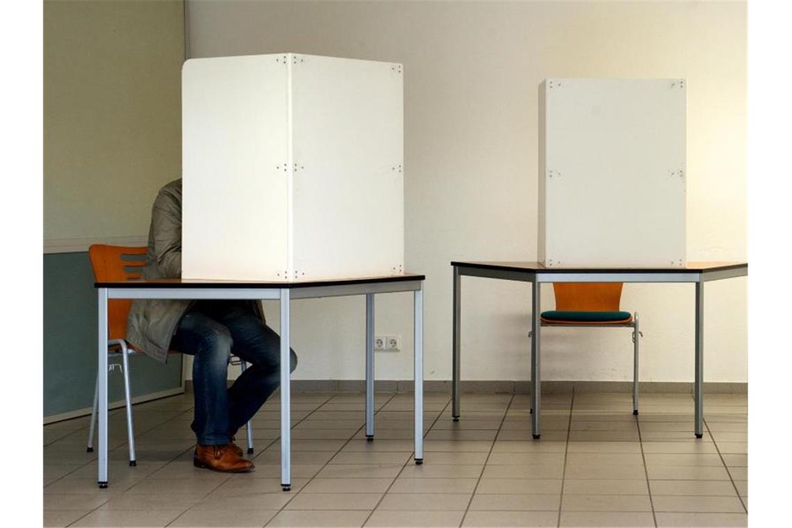 Zeitungen: Landtagswahl am 14. März 2021 Ein Mann sitzt in einer Wahlkabine. Foto: Peter Endig/dpa-Zentralbild/Archiv