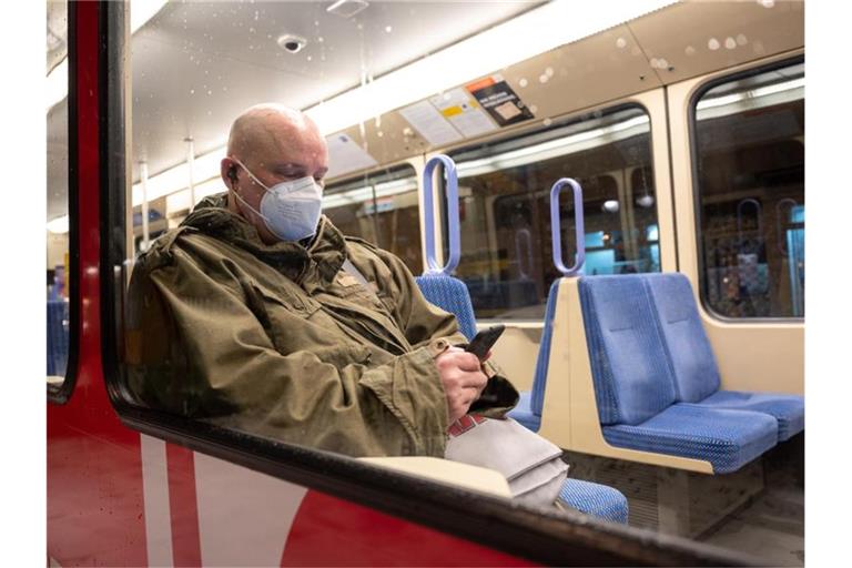 Ein Mann sitzt mit einer FFP2-Maske in einer U-Bahn. Foto: Sebastian Gollnow/dpa/Archivbild