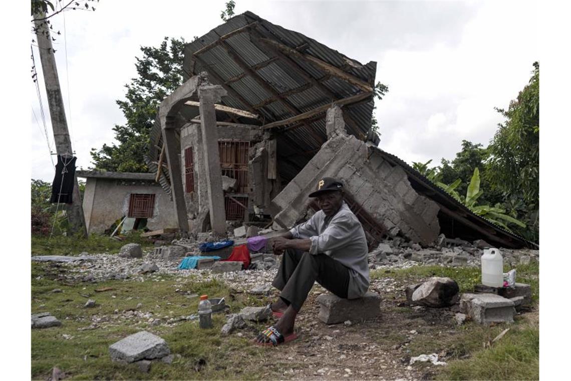Beben in Haiti: 24 Menschen nach über einer Woche gerettet Ein Mann sitzt vor einem zerstörten Haus in Haiti. Foto: David de la Paz/XinHua/dpa