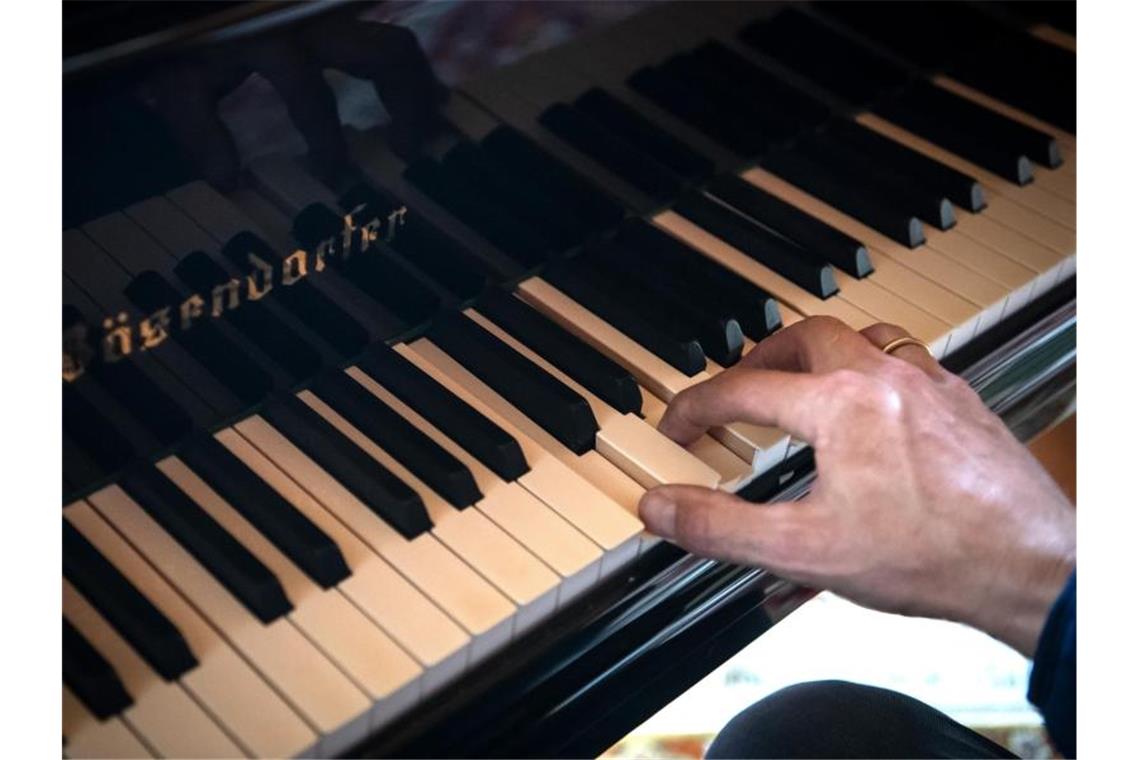 Ein Mann spielt auf einem Flügel. An der Hochschule für Musik in Freiburg gibt es erstmals eine Aufnahmeprüfung, bei der Studienbewerber aus dem Ausland per ferngesteuertem Klavier vorspielen. Foto: Sina Schuldt/dpa/Archivbild