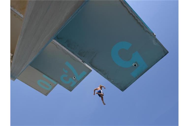 Ein Mann springt im Freibad vom 7,5-Meter-Turm. Foto: Patrick Seeger