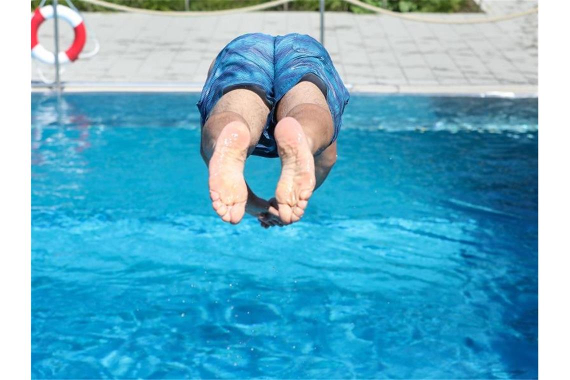 Auch in diesem Jahr maue Bilanz für Freibäder im Südwesten Ein Mann springt von einem Sprungbrett kopfüber ins Wasser. Foto: Thomas Warnack/dpa