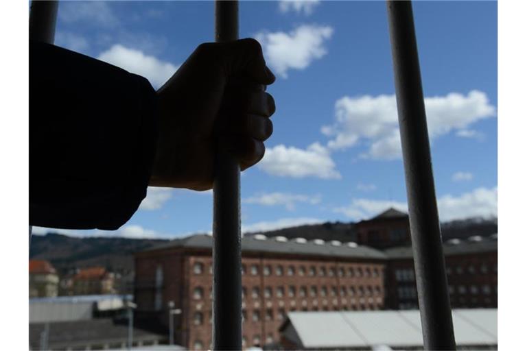 Ein Mann steht im Block der Sicherheitsverwahrten vor einem vergitterten Fenster. Foto: Patrick Seeger/dpa/Symbolbild